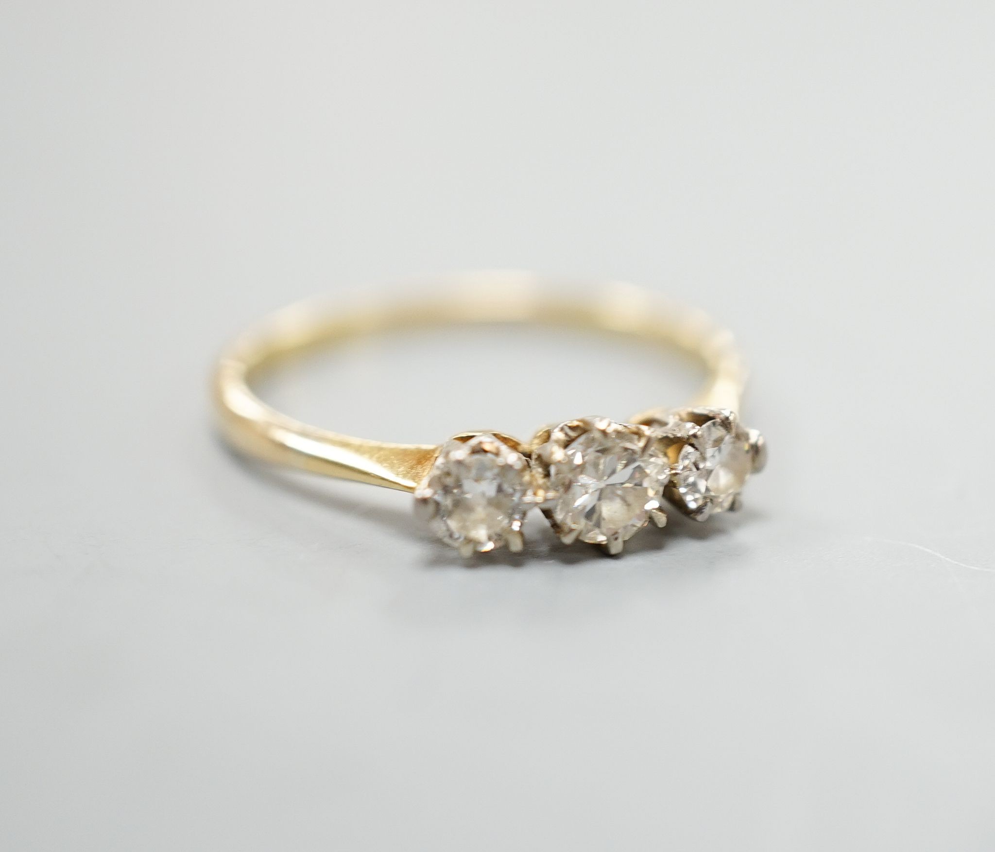 An 18ct and three stone diamond set ring, size P/Q, gross weight 1.7 grams.